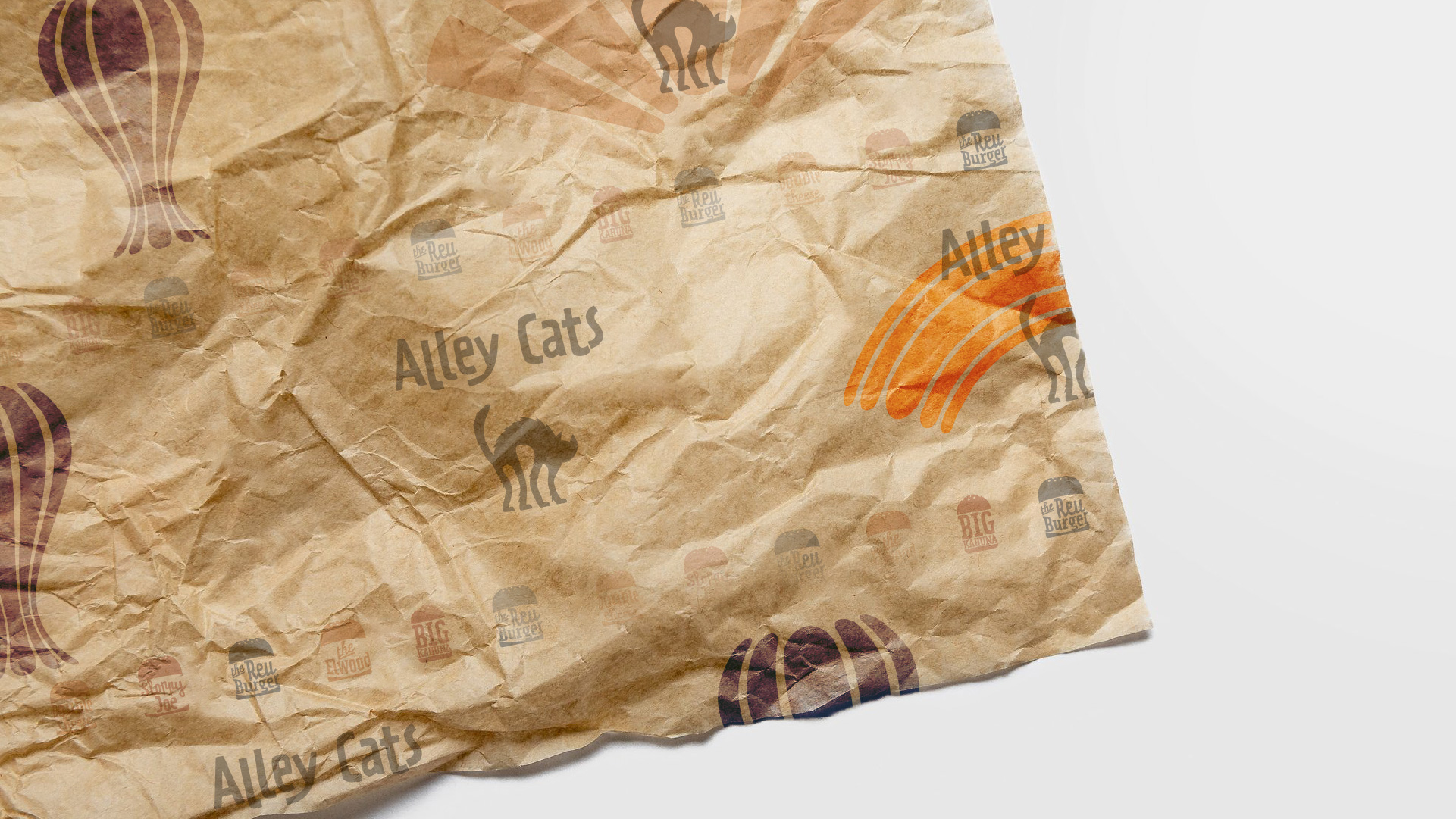 Branded and printed wrapping paper containing the alley cats logo and brand visual assets
