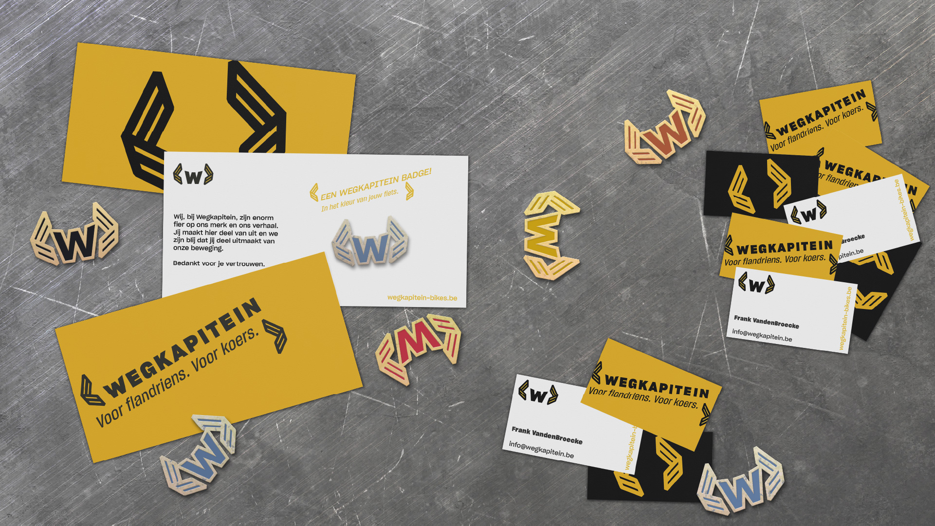 Collection of printed material like business cards and comp slips and enamel pins of the logo
